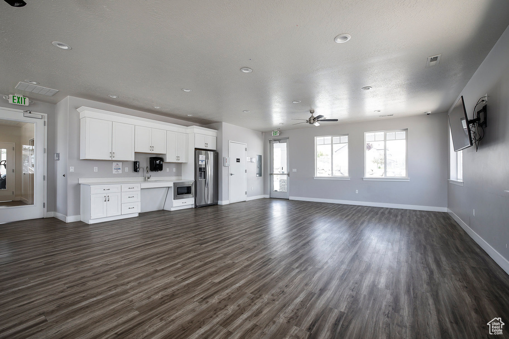 Unfurnished living room featuring dark wood finished floors, a ceiling fan, and recessed lighting