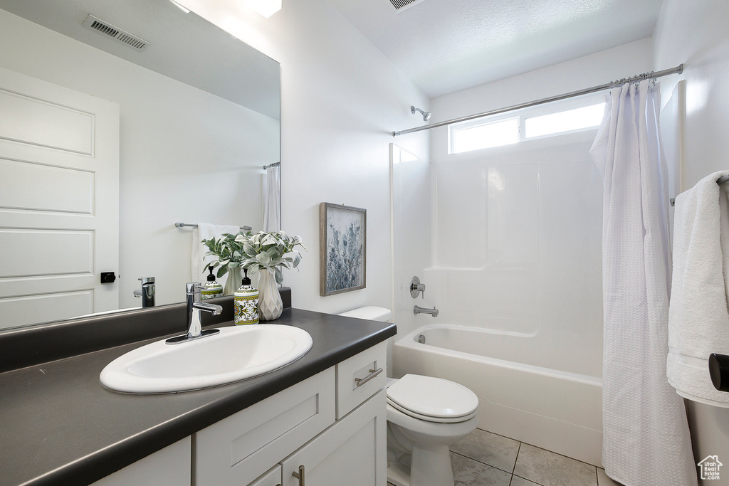 Full bathroom with shower / bath combination with curtain, vanity, and tile patterned floors