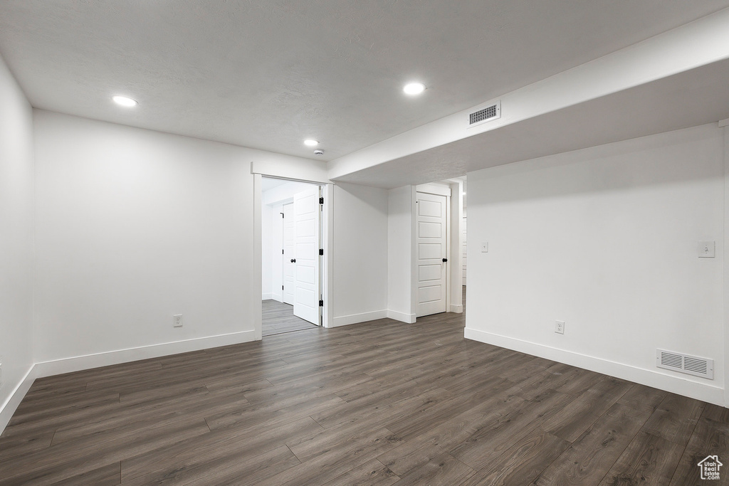 Finished below grade area featuring recessed lighting and dark wood-type flooring