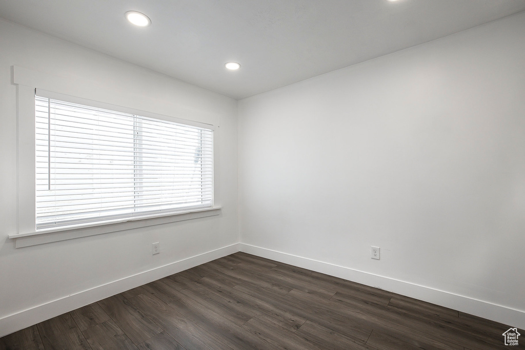 Empty room featuring dark wood-style floors and recessed lighting