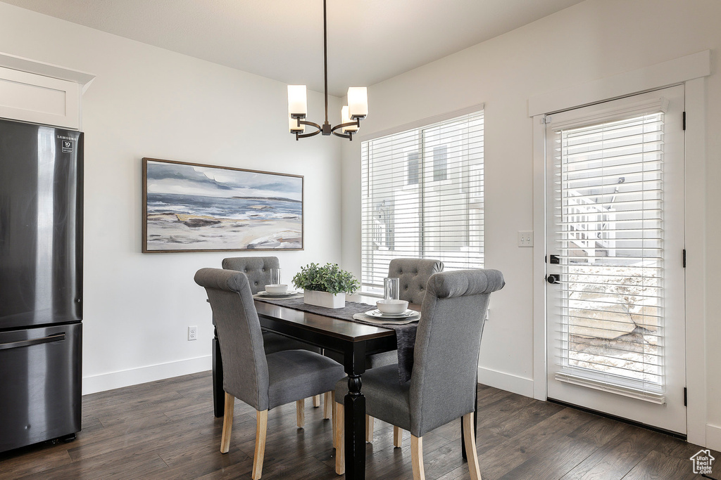 Dining area with a chandelier, dark wood-style floors, and plenty of natural light