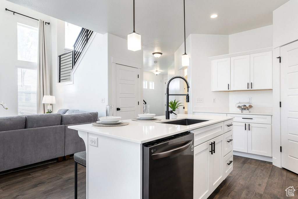 Kitchen featuring dishwasher, open floor plan, healthy amount of natural light, a kitchen breakfast bar, and recessed lighting