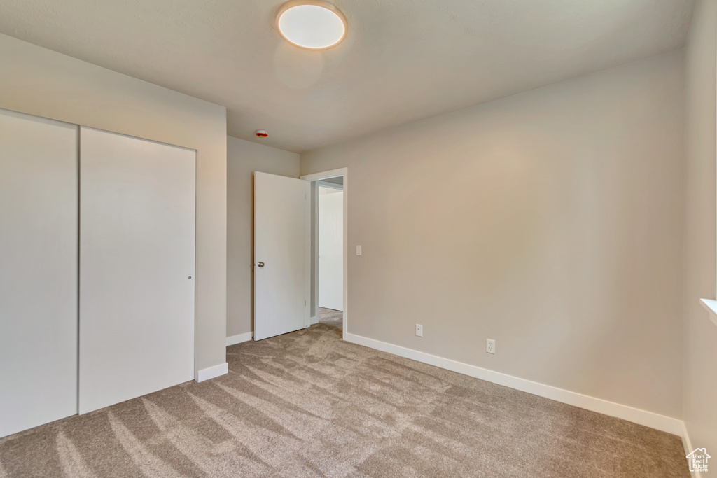 Unfurnished bedroom featuring carpet flooring and a closet