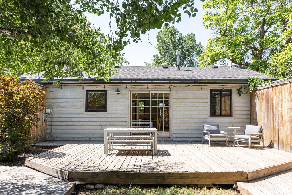Rear view of property featuring a wooden deck and a shingled roof