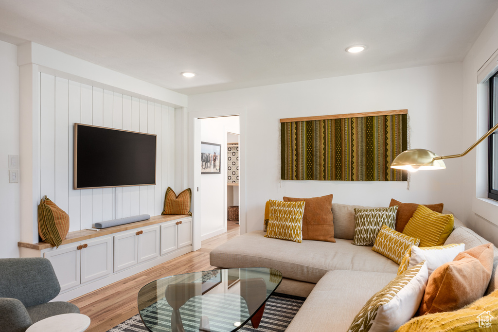 Living room with light wood finished floors and recessed lighting