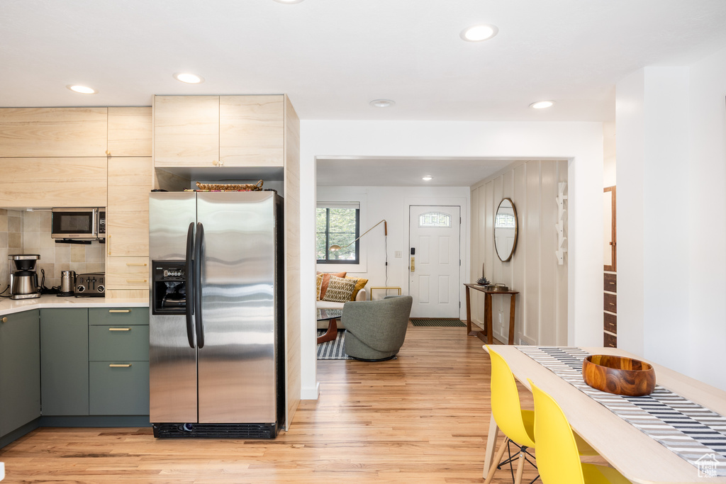 Kitchen featuring stainless steel appliances, light wood finished floors, light countertops, recessed lighting, and tasteful backsplash