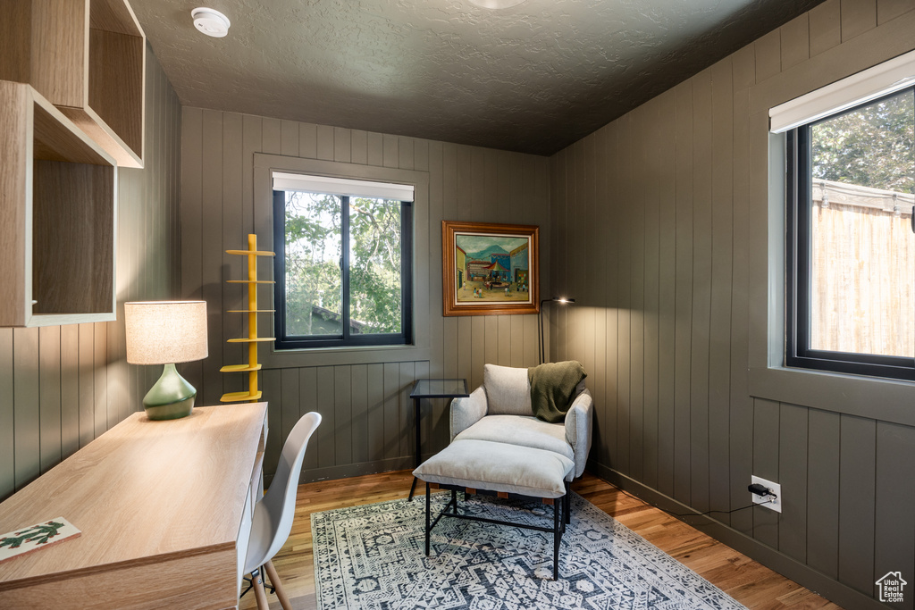 Home office with wood finished floors and a textured ceiling