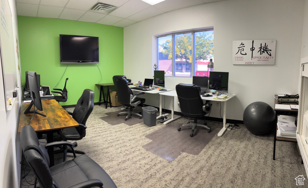 Office area with a drop ceiling and carpet floors
