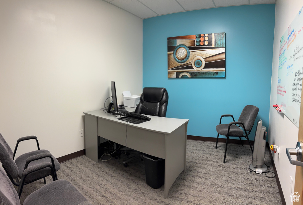 Office space with a paneled ceiling and carpet floors