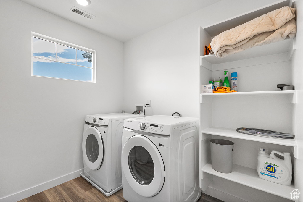 Washroom with washer and clothes dryer and wood finished floors
