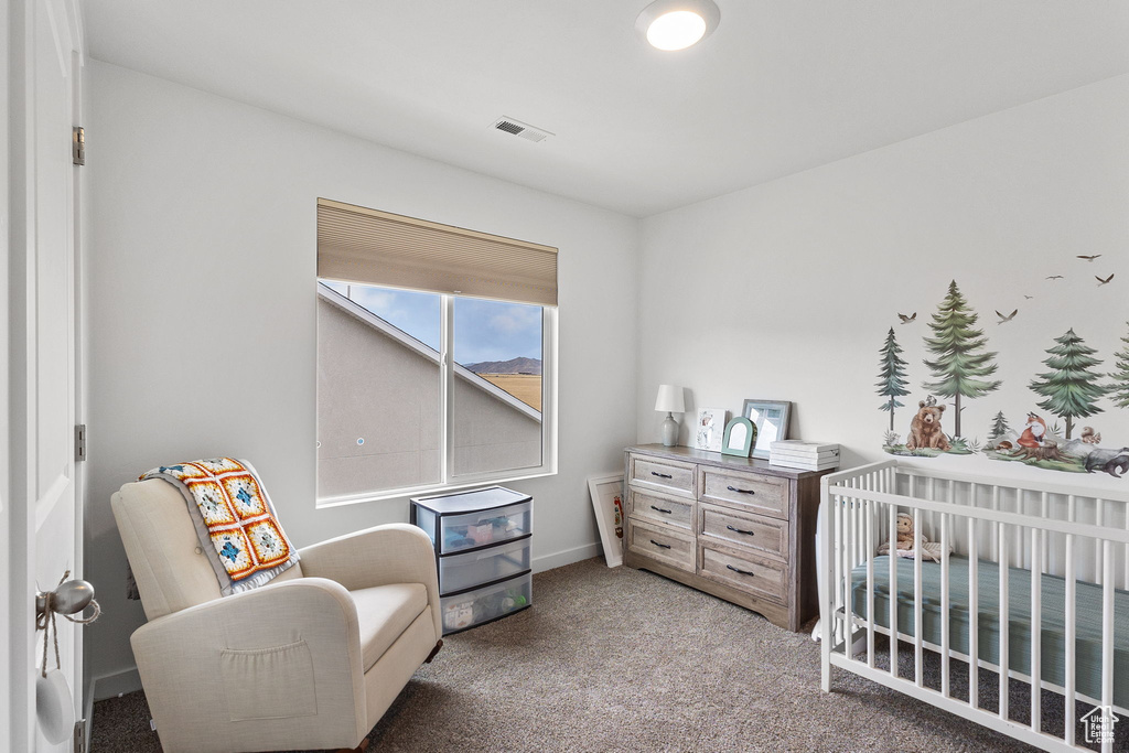 Bedroom featuring light carpet and a crib
