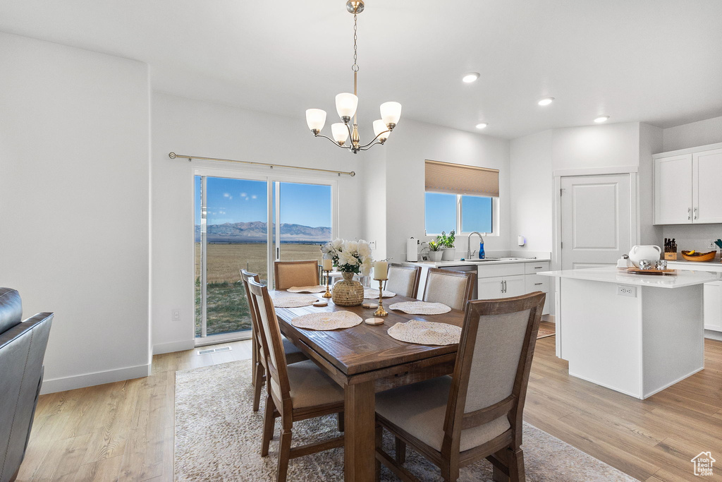 Dining area featuring light wood-style flooring, recessed lighting, a chandelier, and a mountain view