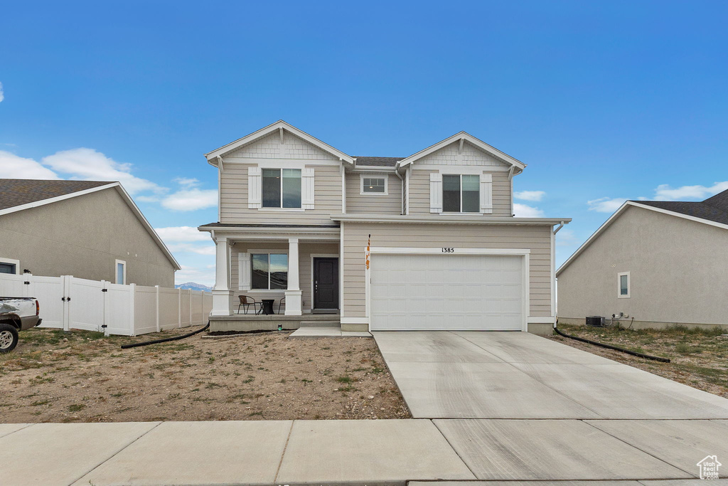 Craftsman-style house with a porch, driveway, and an attached garage