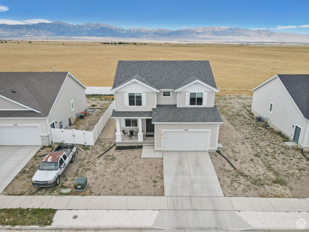 View of front of property featuring a view of rural / pastoral area, concrete driveway, a mountain view, a gate, and roof with shingles