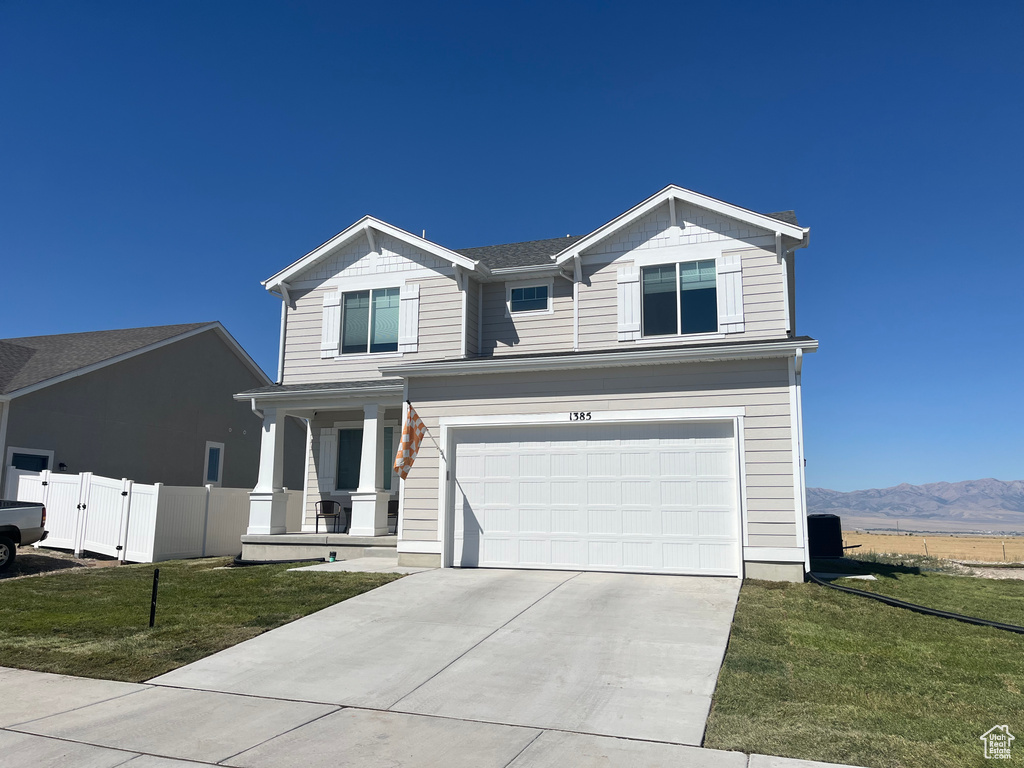 View of front of house with a porch, driveway, and an attached garage