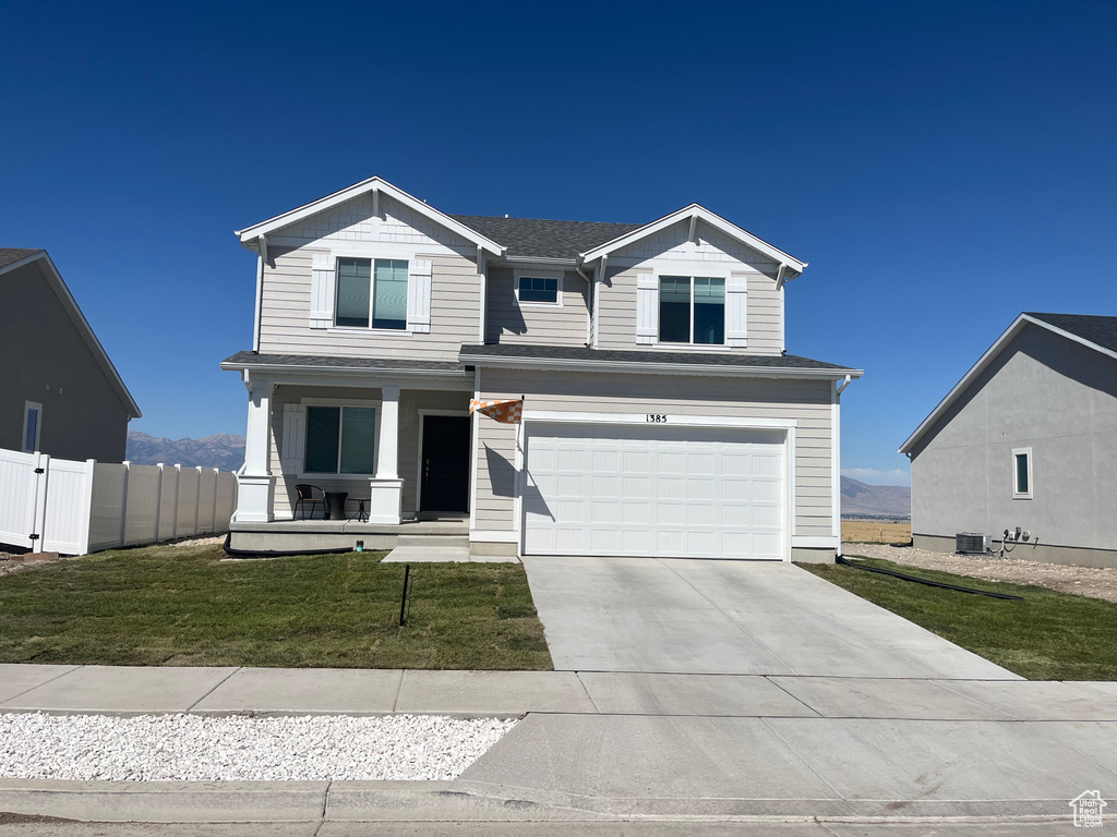 View of front facade with a porch, driveway, and an attached garage
