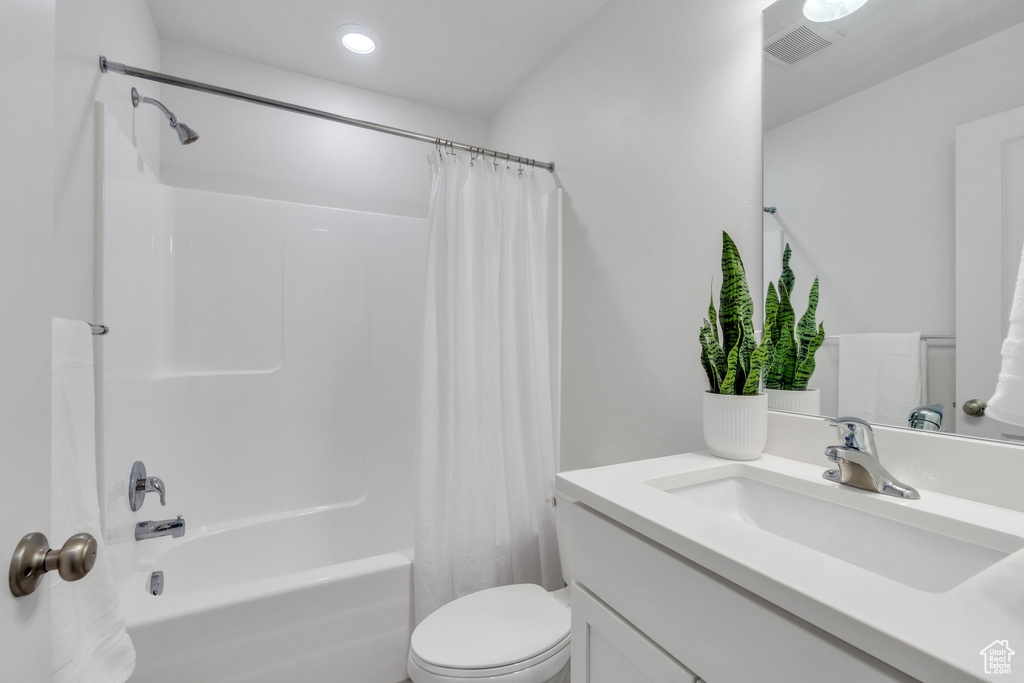 Full bathroom featuring vanity, shower / bath combo, and recessed lighting