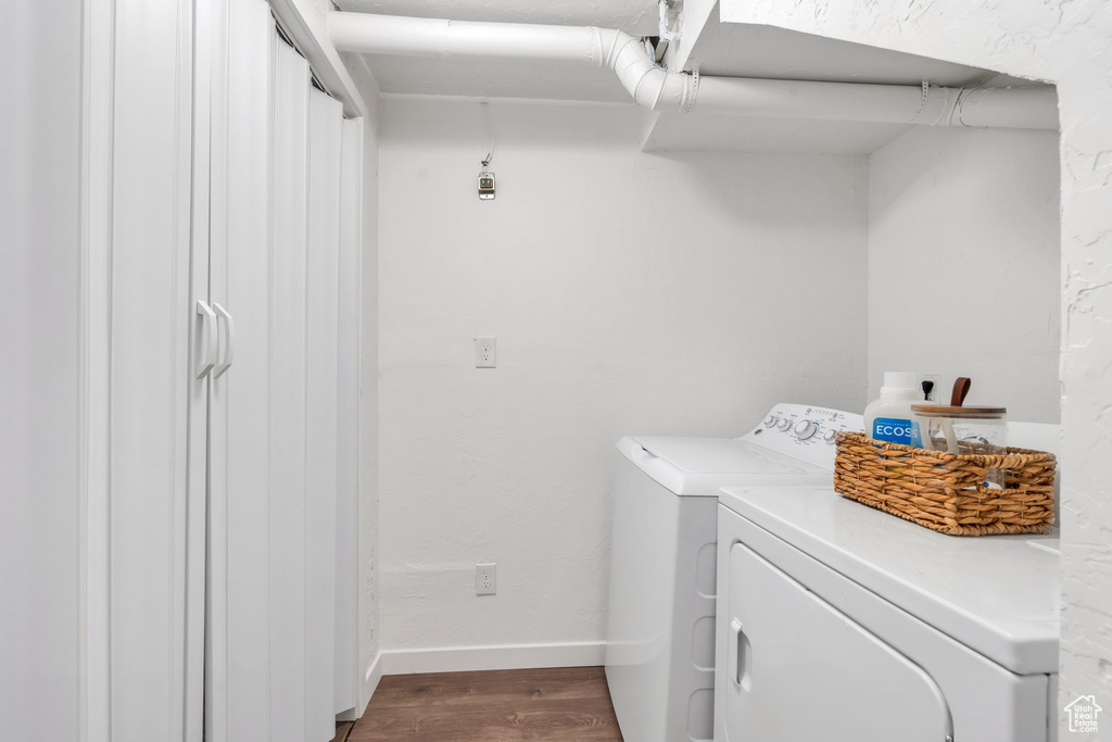 Washroom featuring washer and dryer and dark wood finished floors