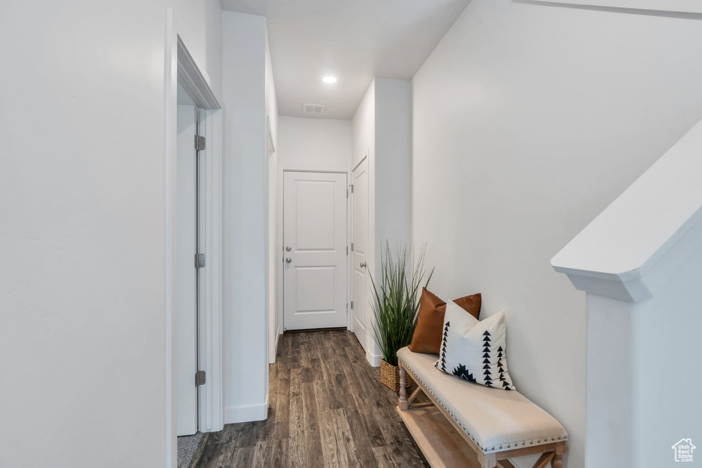 Hall with dark wood-type flooring and recessed lighting