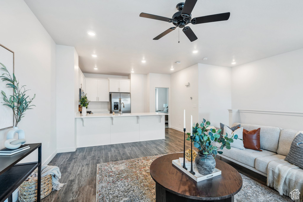 Living area with dark wood-style floors, ceiling fan, and recessed lighting