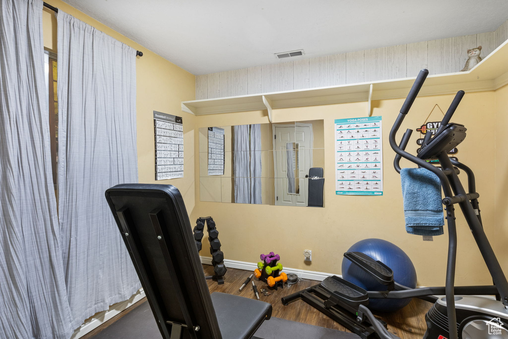 Workout area with wood finished floors and baseboards
