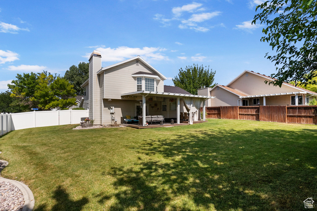 Back of house with a fenced backyard, a chimney, an outdoor living space, and a patio