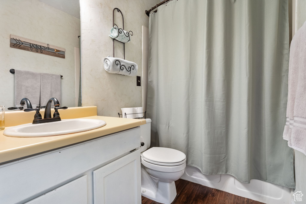 Bathroom with vanity, wood finished floors, and shower / bath combo
