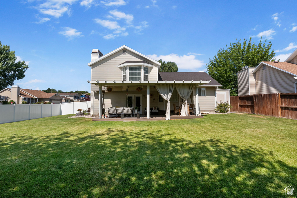 Back of property with a fenced backyard, a chimney, and ceiling fan