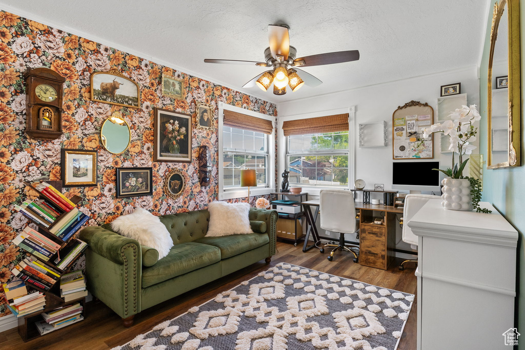 Home office with a ceiling fan, wood finished floors, a textured ceiling, wallpapered walls, and ornamental molding