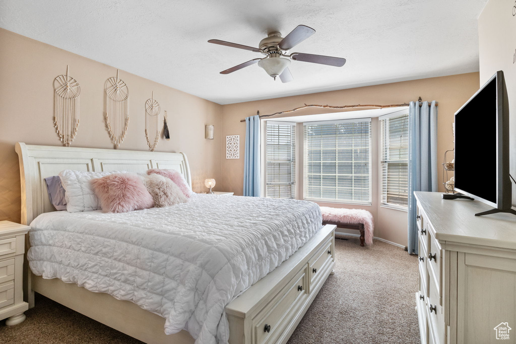 Carpeted bedroom featuring a ceiling fan