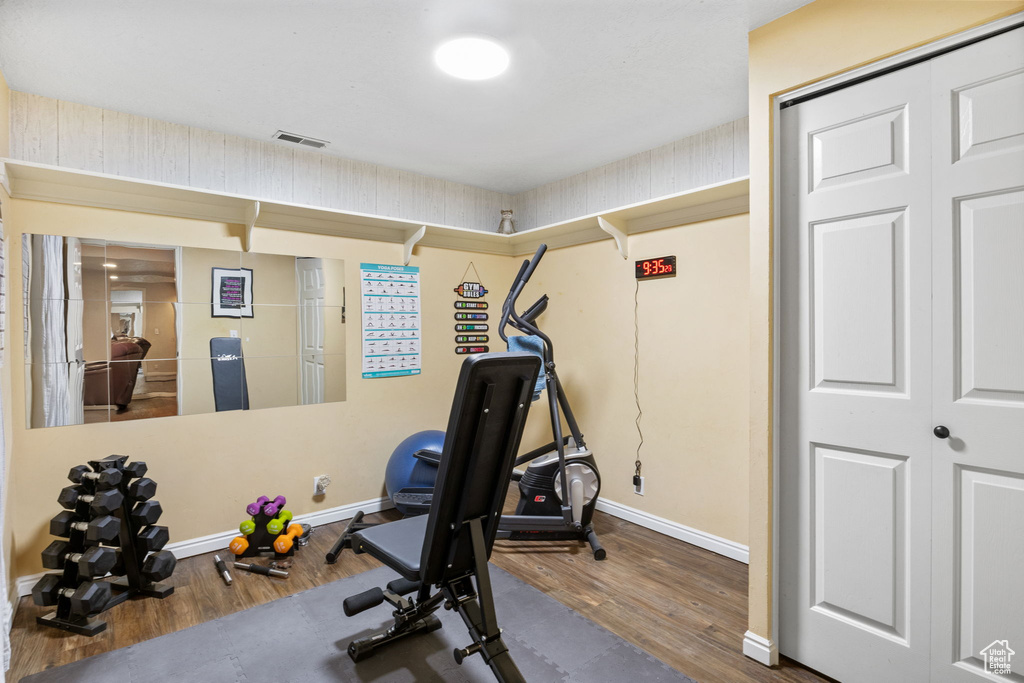 Exercise room with wood finished floors and baseboards