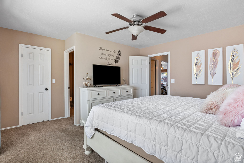 Carpeted bedroom featuring baseboards and a ceiling fan