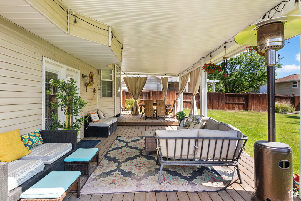Deck with an outdoor hangout area, outdoor dining space, and a fenced backyard