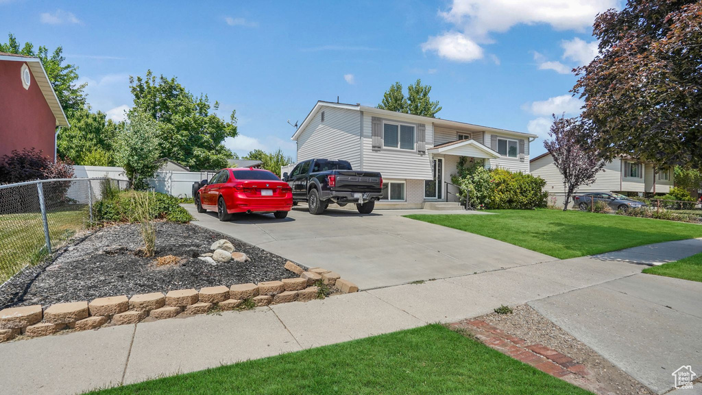 Bi-level home featuring brick siding and concrete driveway