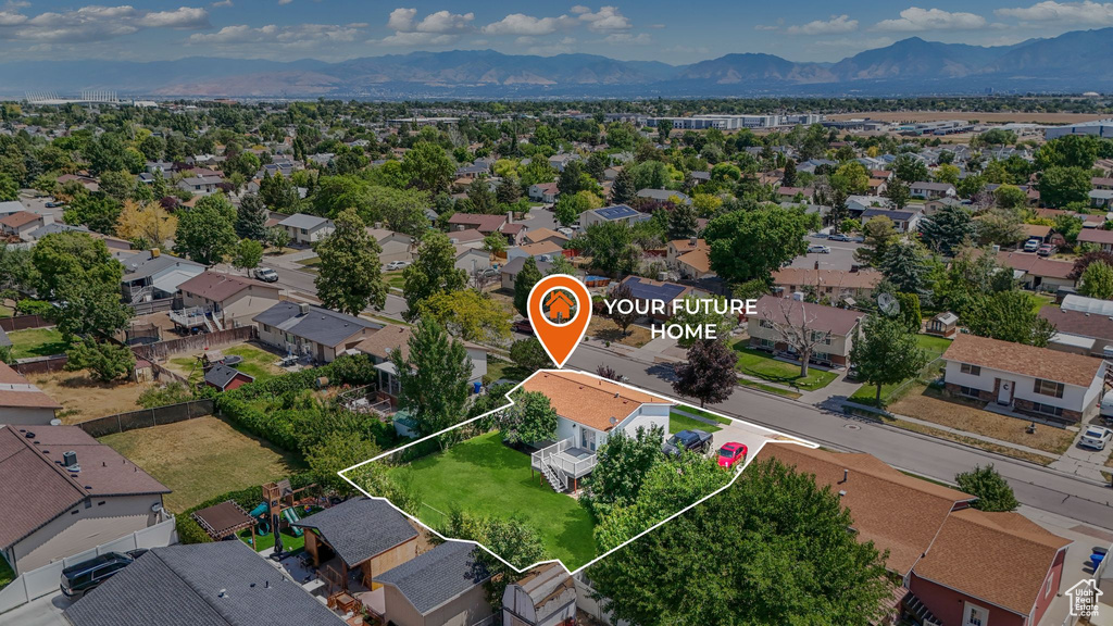 Aerial view of residential area featuring a mountainous background and property parcel outlined