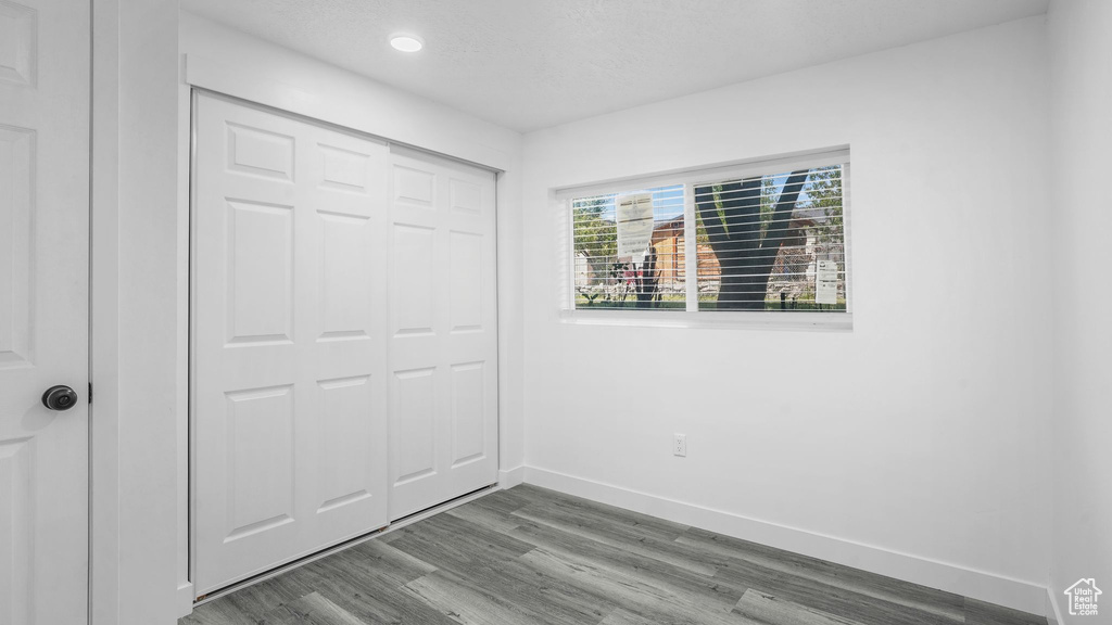Unfurnished bedroom with wood finished floors, a closet, and recessed lighting