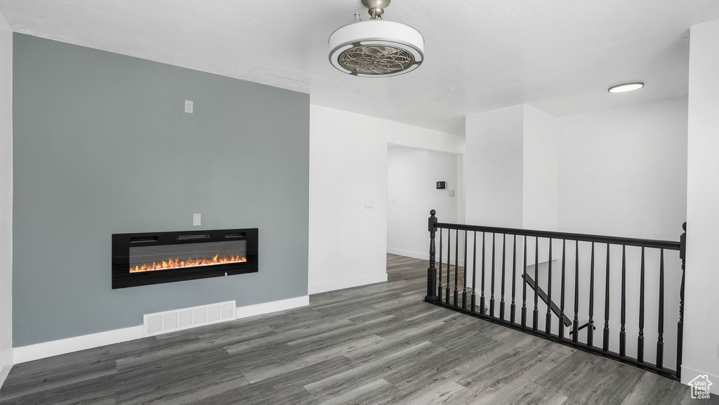 Empty room with wood finished floors and a glass covered fireplace