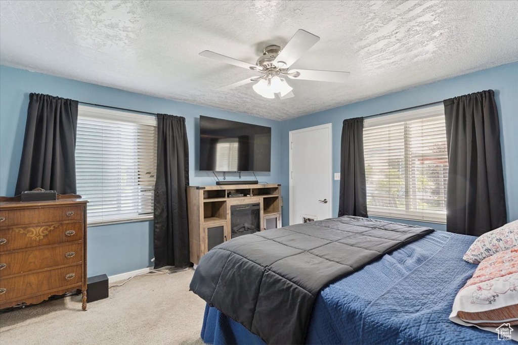 Bedroom featuring carpet flooring, a textured ceiling, and ceiling fan