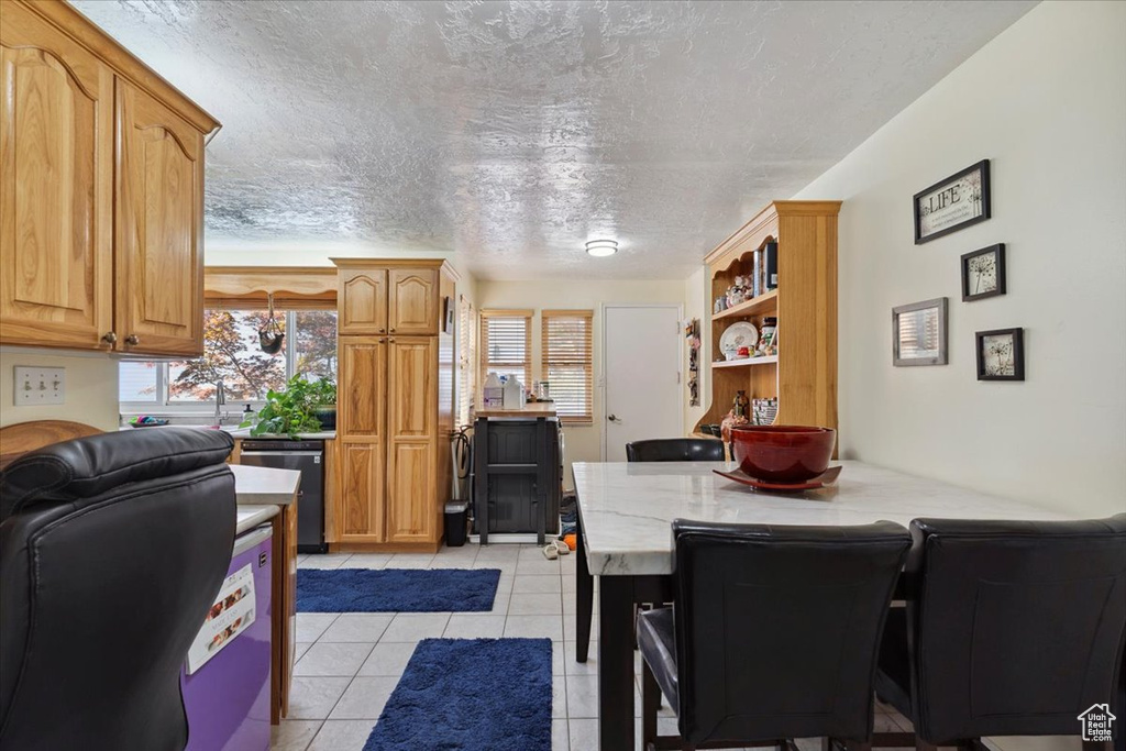 Dining room featuring light tile patterned floors and a textured ceiling