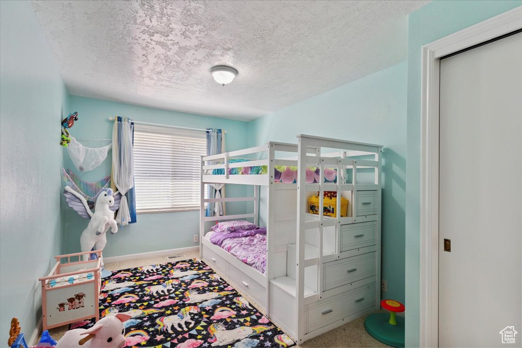Bedroom featuring a textured ceiling and carpet flooring