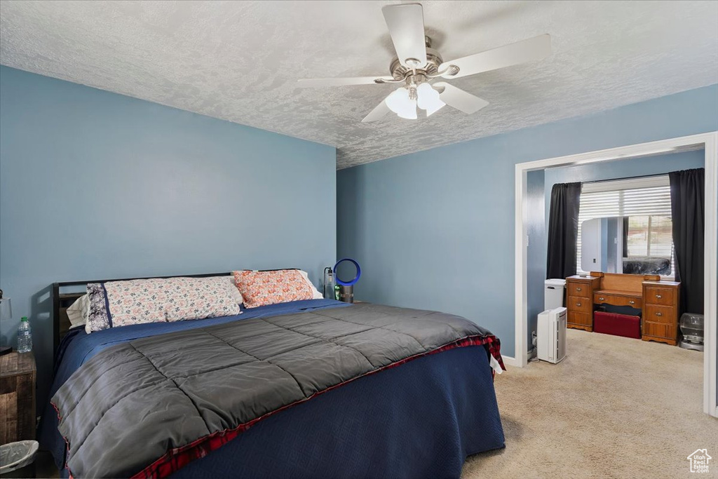 Bedroom with carpet flooring, a textured ceiling, and a ceiling fan