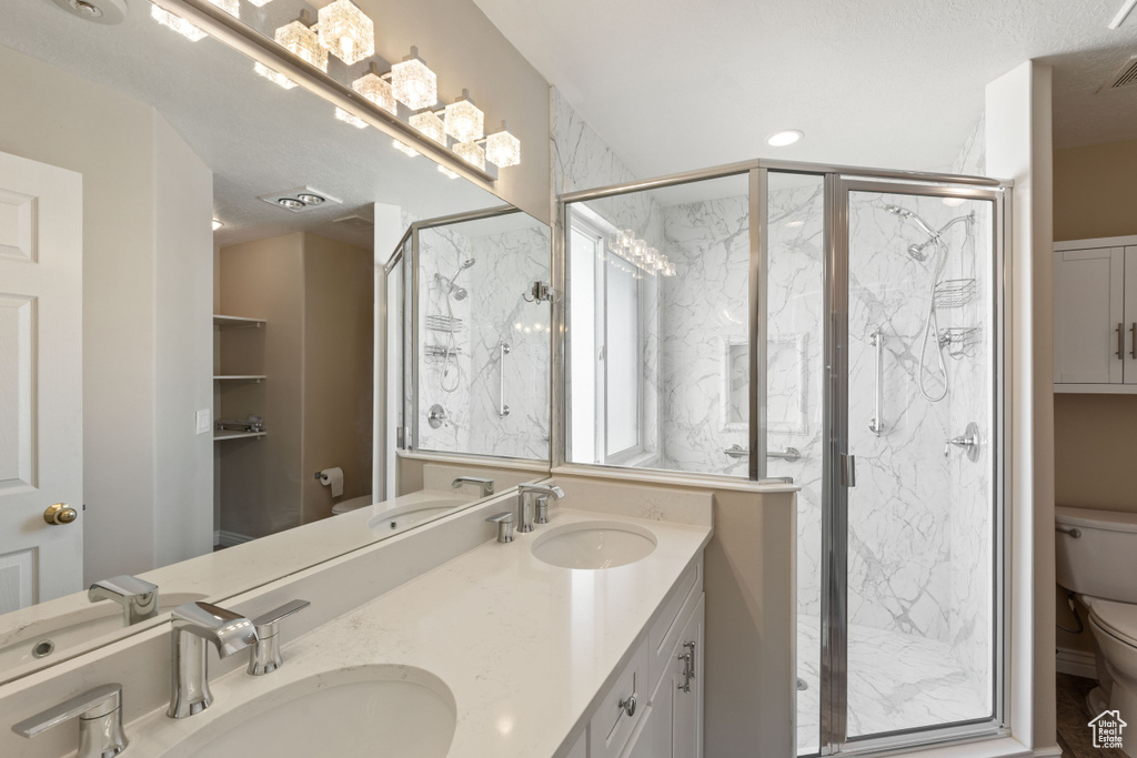 Bathroom with a marble finish shower and double vanity