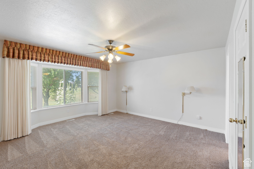 Unfurnished room with carpet floors and a ceiling fan