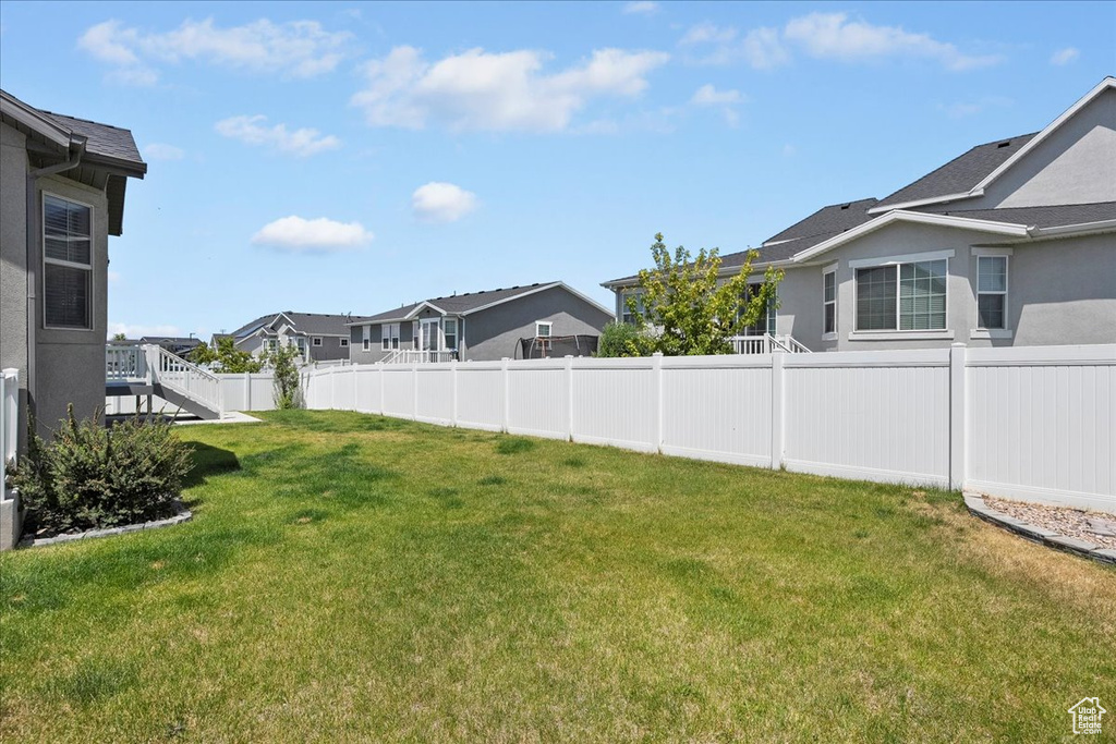 Fenced backyard featuring a residential view and stairs
