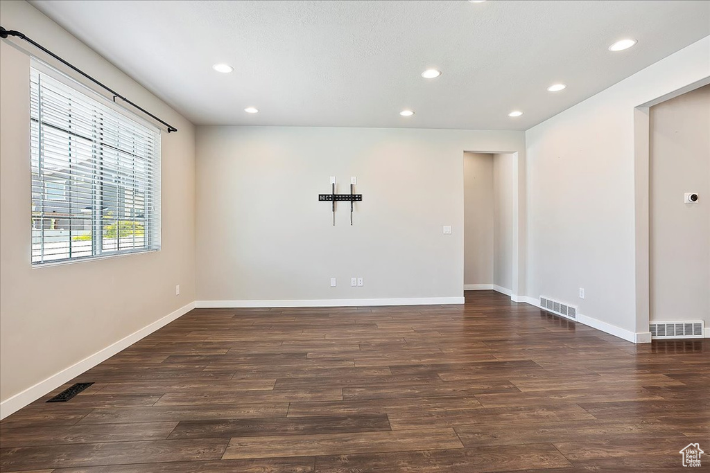 Spare room featuring dark wood-type flooring and recessed lighting
