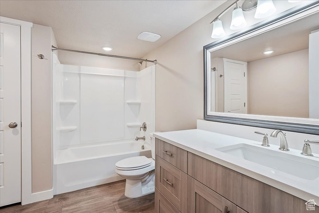 Bathroom with wood finished floors, vanity, and bathtub / shower combination