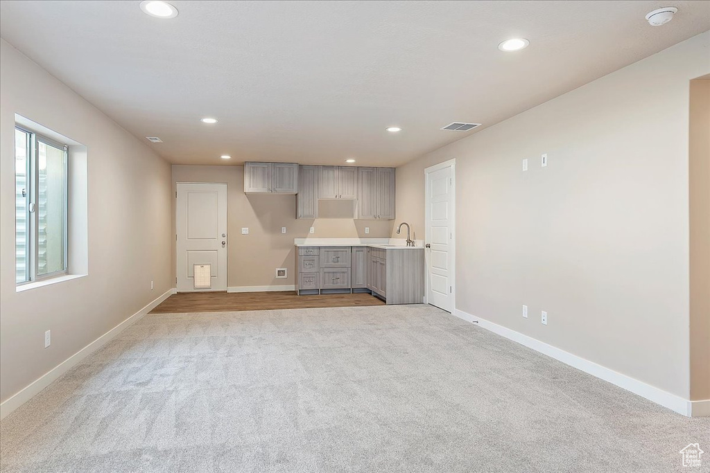 Unfurnished living room with light colored carpet and recessed lighting