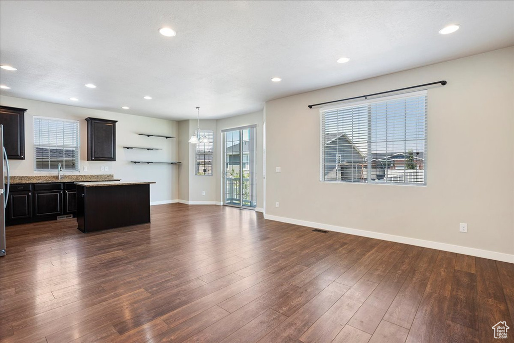 Kitchen with a center island, light countertops, dark wood-style flooring, recessed lighting, and open floor plan