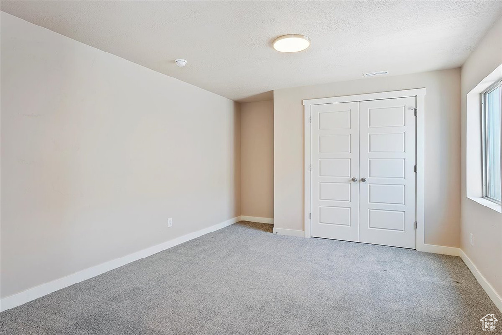 Unfurnished bedroom with carpet flooring and a closet