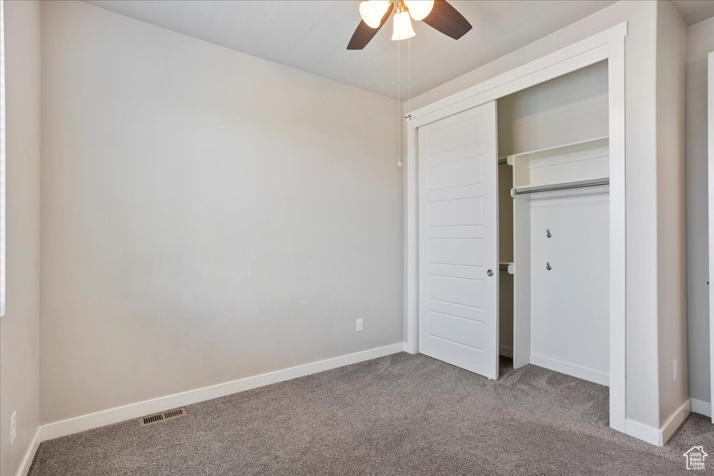 Unfurnished bedroom with carpet, a closet, and ceiling fan